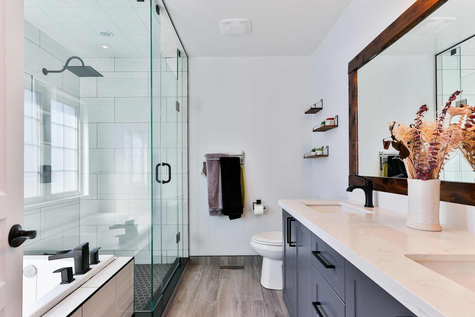 Common bathroom with glass shower screen and timber-look floor tiles