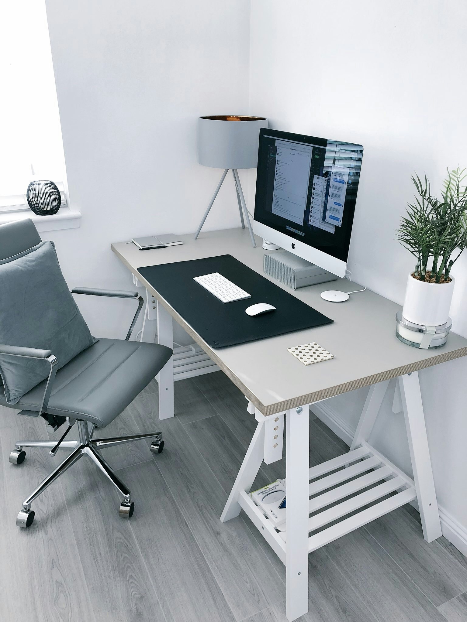 A design desk with an iMac, drawings and material samples during renovation planning